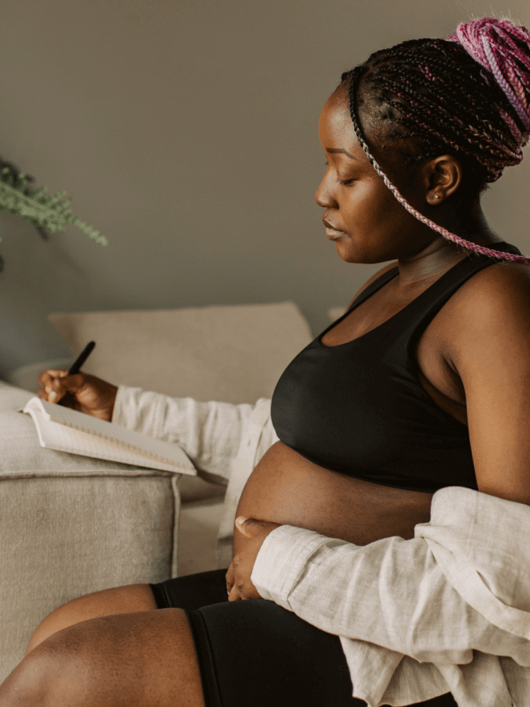 Pregnant woman writing a list of tools and techniques to help during labour